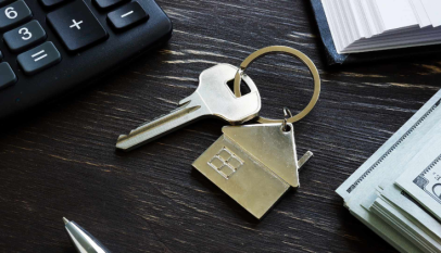 Shot of new house keys, home loans, and other mortgage materials such as a calculator and ledger.